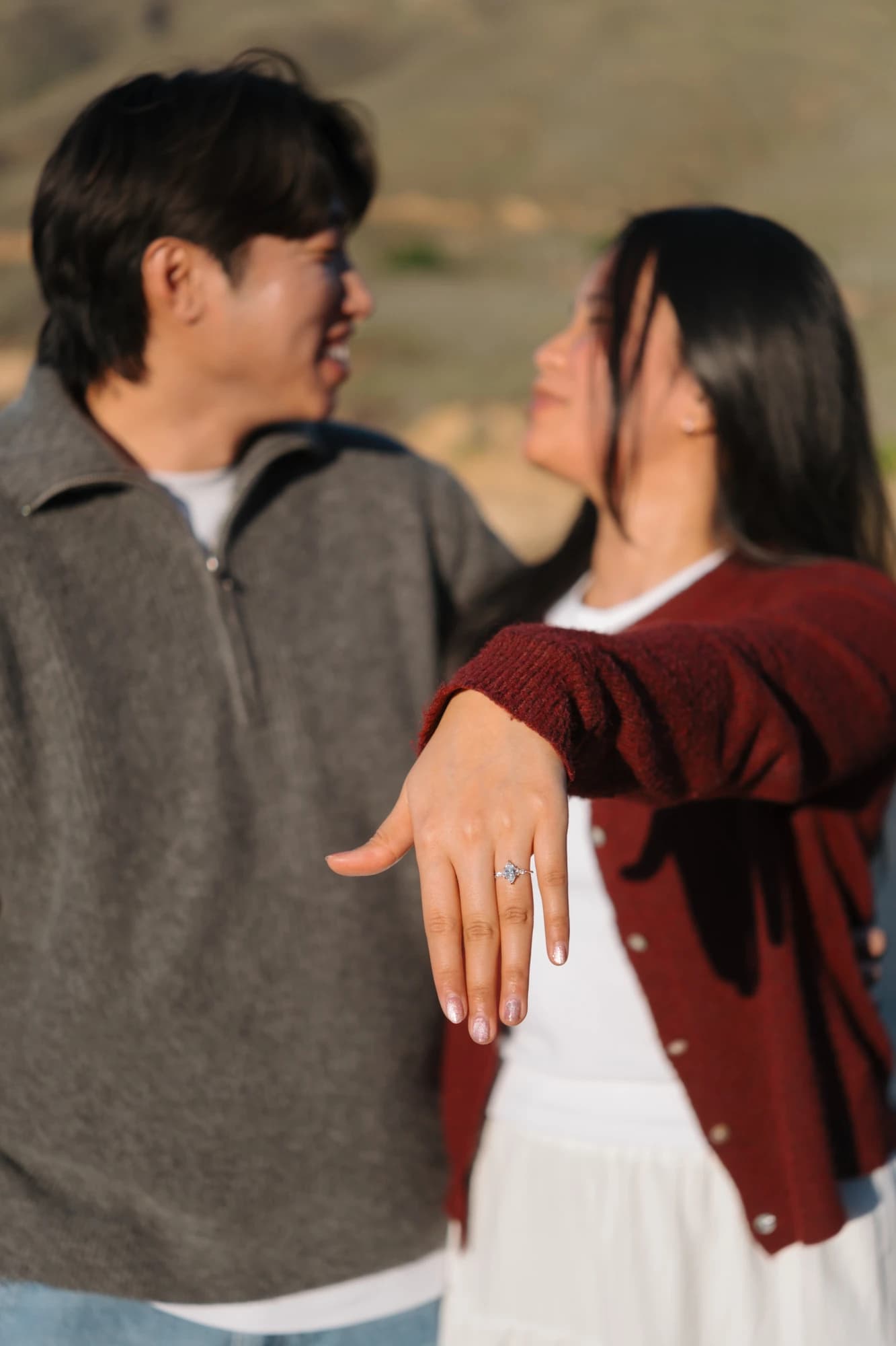 Angel's engagement ring, with Angel and Mickey smiling in the background