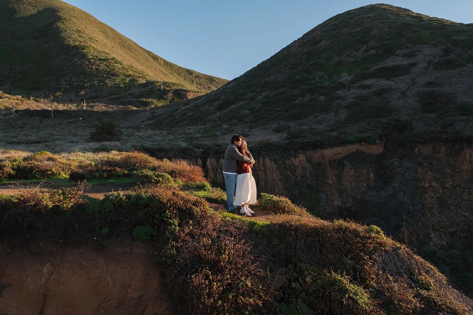 Angel and Mickey on a cliff overlooking the hills