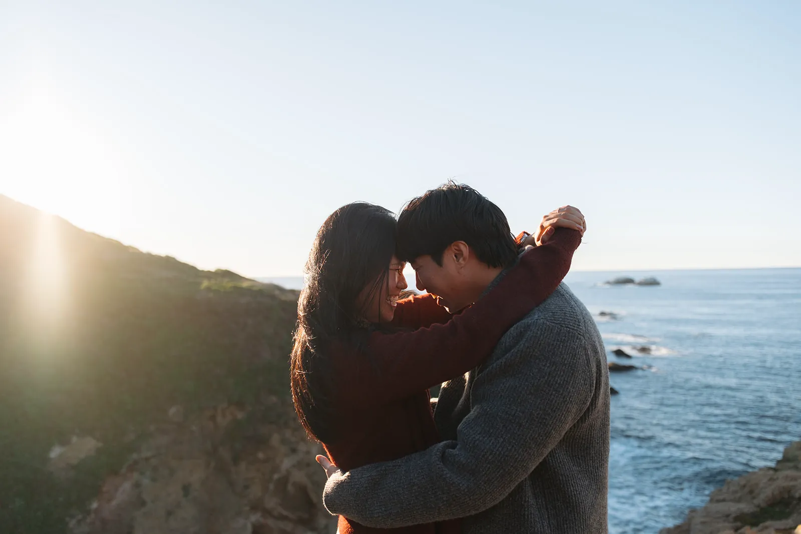 Angel and Mickey embracing on a cliff overlooking the ocean
